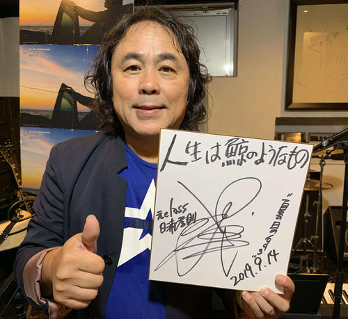 「夏の日の1993」を歌った元classの日浦氏は、巨人の「93年世代」へのメッセージ入りの色紙を持ちサムアップ