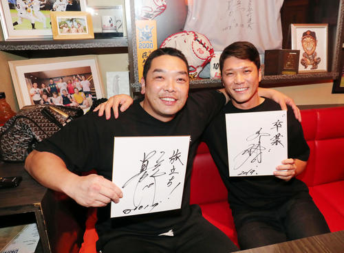 対談後、巨人阿部（左）は「旅立ち！」、坂本勇は「卒業」と色紙に記し肩を組み笑顔で写真に納まる（撮影・垰建太）