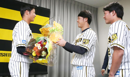 引退会見を終えた横田慎太郎（左）にサプライズで花束贈呈する、高山俊（中央）と北條史也（撮影・上山淳一）