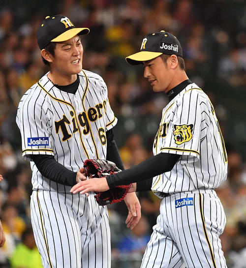 阪神対DeNA　2番手で登板し、後続を抑えた能見（右）をベンチ前で出迎える望月（撮影・上田博志）