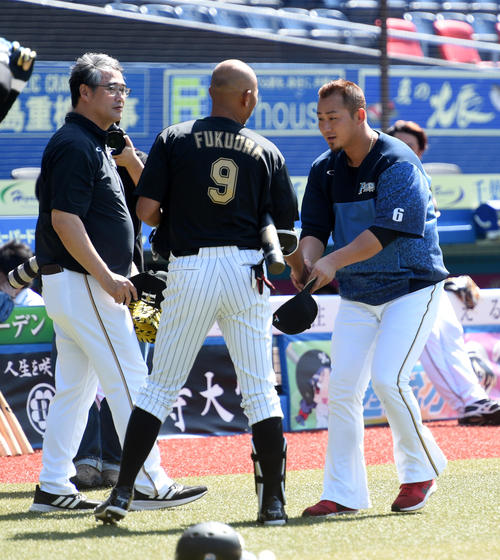 引退試合を前に、日本ハム中田（右）と握手するロッテ福浦、左は日本ハム木田投手コーチ（撮影・柴田隆二）