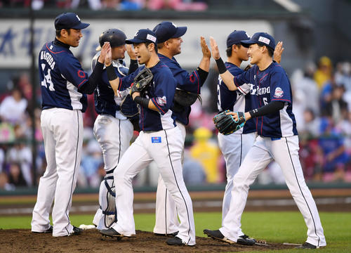 楽天対西武　楽天に勝利し、30セーブの西武増田（左）は笑顔でナインとタッチを交わす（撮影・横山健太）