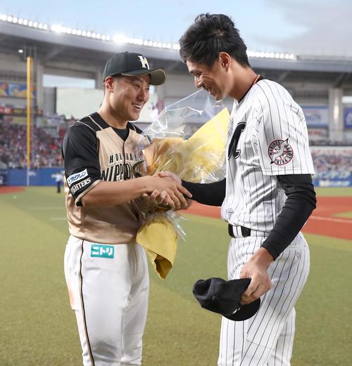 ロッテ対日本ハム　試合後、岡（右）から花束を受け取る田中賢（撮影・黒川智章）
