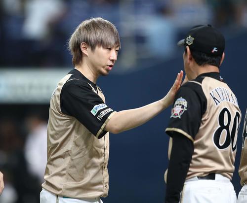 オリックス対日本ハム　試合後、栗山監督とハイタッチする金子（撮影・黒川智章）