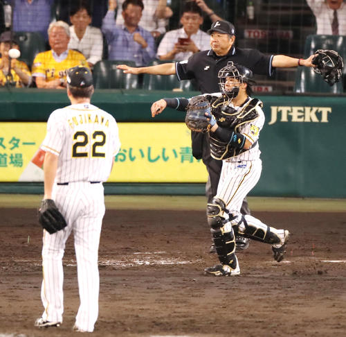 阪神対巨人　9回表巨人2死、山本の三振の時、こぼれ球を一塁へ送球する梅野、左は藤川（撮影・加藤哉）