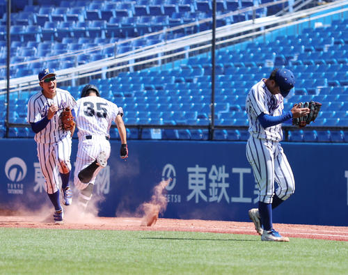 立正大対亜大　9回裏亜大2死、最終打者を一ゴロに抑えグラブをたたき喜ぶ立正大・糸川（右）。左は佐々木勝（撮影・河田真司）