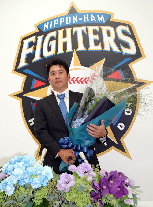 日本ハム対オリックス　試合前、引退会見を終え花束を手に撮影に応じる日本ハム実松2軍育成コーチ兼捕手（撮影・佐藤翔太）