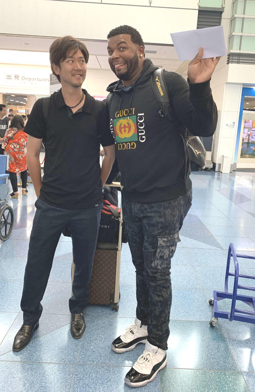 ロッテ・バルガスは帰国前の羽田空港でおどけた表情を見せる。左は田原通訳