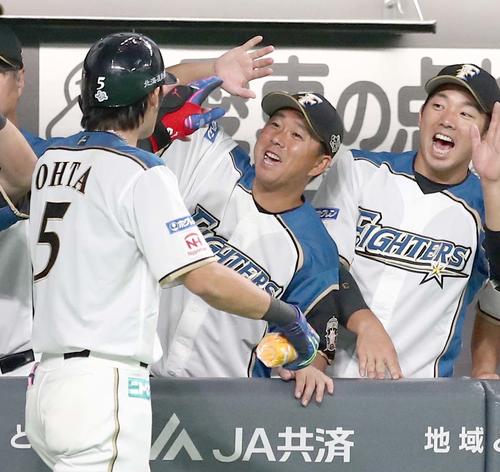 日本ハム対オリックス　4回裏、本塁打を放った大田を出迎える実松兼任コーチ（右から2人目）（撮影・黒川智章）