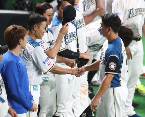 日本ハム対オリックス　試合後、引退する実松（右）と笑顔で握手する田中賢（撮影・黒川智章）
