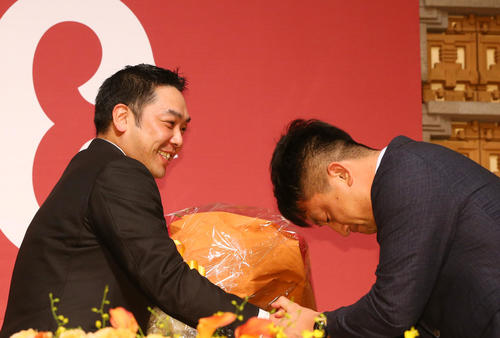 引退会見で巨人阿部（左）は沢村から花束を贈られガッチリ握手を交わす（2019年9月25日）
