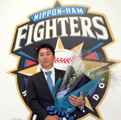 引退会見を終え花束を手に撮影に応じる日本ハム実松2軍育成コーチ兼捕手（撮影・佐藤翔太）