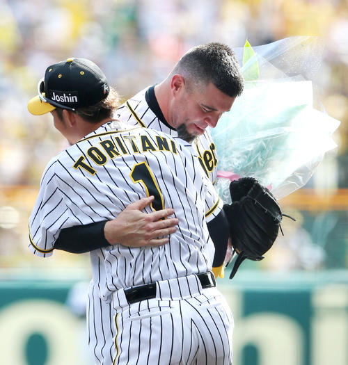 阪神対中日　鳥谷（手前）から花束を贈られ抱き合うメッセンジャー（撮影・上山淳一）