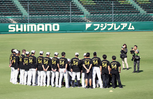 阪神対中日　練習前、メッセンジャーTシャツを着てメッセンジャーと記念撮影する阪神の選手とスタッフたち（撮影・前田充）