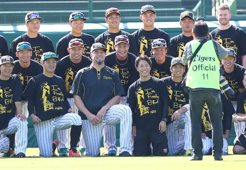 阪神対中日　練習前、メッセンジャーTシャツを着てメッセンジャー（手前左から3人目）と記念撮影する阪神の選手とスタッフたち（撮影・上山淳一）