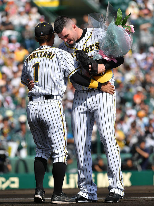 阪神対中日　最終登板を終えたメッセンジャーは花束を手渡した鳥谷と抱き合って笑顔を見せる（撮影・上田博志）
