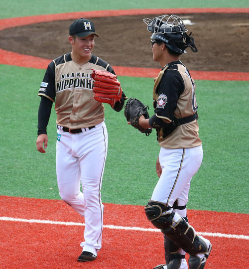 イースタン・リーグ楽天戦で、捕手の郡（右）と笑顔で会話をしながらベンチへと戻る日本ハム吉田輝（撮影・山崎純一）