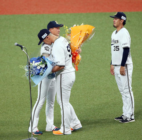 オリックス対ソフトバンク　比嘉（右）とT－岡田（中央）から花束を受け取る岸田（撮影・栗木一考）