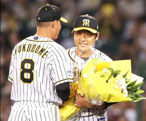 7回表中日無死、最終登板を終えた高橋聡(右)は福留から花束を贈られ笑顔を見せる(撮影・上山淳一)