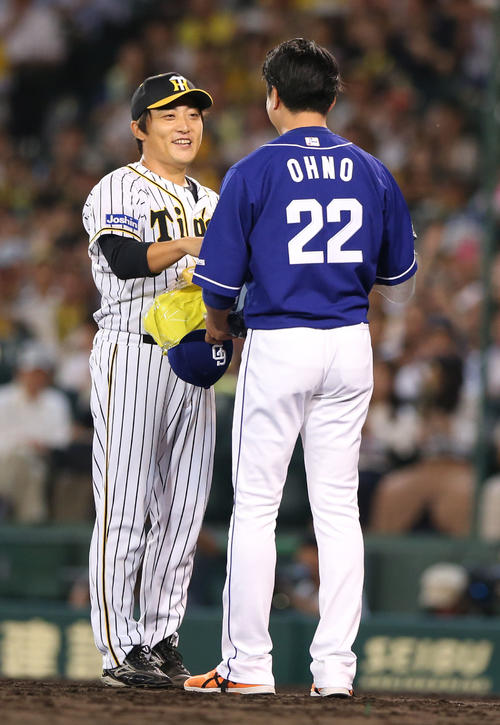 阪神対中日　7回表中日無死、最終登板を終えた高橋聡（左）にサプライズで中日の大野雄から花束が贈られ笑顔を見せる（撮影・上山淳一）