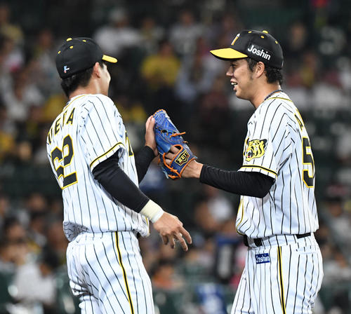 阪神対中日　3回を無失点抑えた青柳晃洋（右）は植田海と笑顔でタッチを交わす（撮影・奥田泰也）