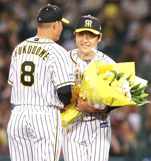 阪神対中日　7回表中日無死、最終登板を終えた高橋聡（右）は福留から花束を贈られ笑顔を見せる（撮影・上山淳一）