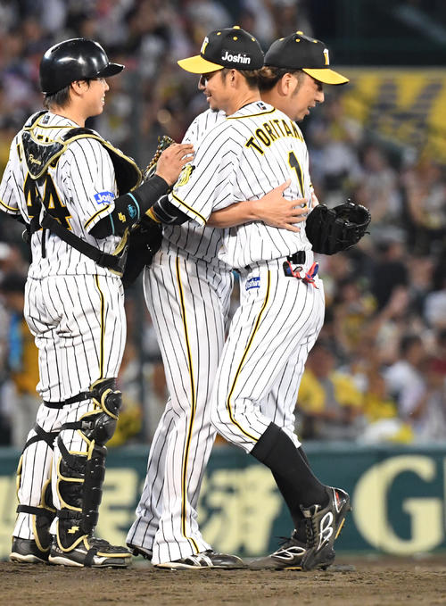 阪神対中日　シーズン最終戦、中日を破り鳥谷敬（右）は藤川球児（中央）と抱き合って喜ぶ左は梅野隆太郎（撮影・奥田泰也）
