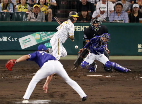 阪神対中日　4回裏阪神2死満塁、暴投で三走福留の生還を許す中日三ツ間（手前）。打者高山（撮影・前田充）