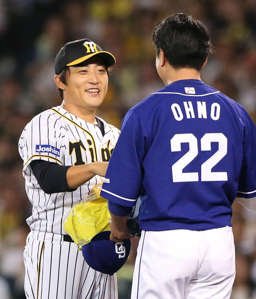 7回表中日1死、最終登板を終えた高橋聡（左）は、中日大野雄からの花束に笑顔を見せる（撮影・上山淳一）