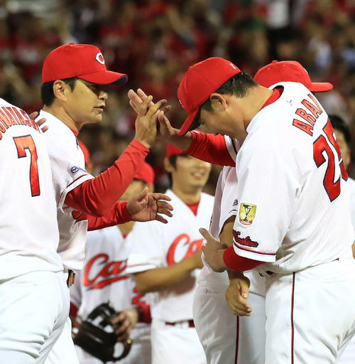 2018年9月、セ・リーグ優勝を決め広島緒方監督（左）とタッチを交わす新井（撮影・江口和貴）