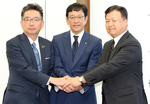 続投が決まった日本ハムの栗山監督（中央）は、畑オーナー（右）と川村球団社長（左）と笑顔で握手する（撮影・浅見桂子）