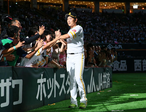 ソフトバンク対楽天　ファンとタッチを交わすソフトバンク石川（撮影・足立雅史）