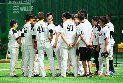試合前練習前、投手陣の円陣の中央で笑顔を見せるソフトバンク高橋礼（撮影・足立雅史）