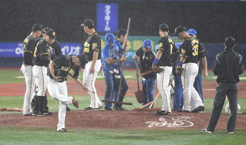 DeNA対阪神　9回裏DeNA無死、ロペスに四球を与えた後、降雨のためマウンドに土が入れられる。手前はスパイクの土を落とす藤川（撮影・鈴木みどり）