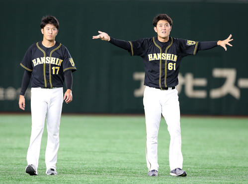 投手指名練習に参加しウオーミングアップする望月（右）と岩貞（撮影・加藤哉）