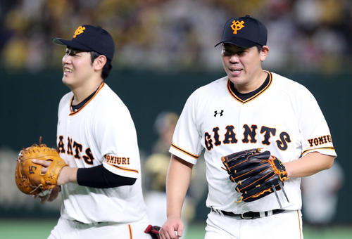巨人対阪神　7回表阪神2死一塁、梅野隆太郎の打球を好捕した岡本（左）と笑顔で引き揚げる山口（撮影・垰建太）