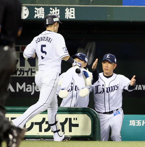 西武対ソフトバンク　4回裏西武2死、外崎はソロ本塁打を放ち辻監督（右）の出迎えを受ける（撮影・栗木一考）