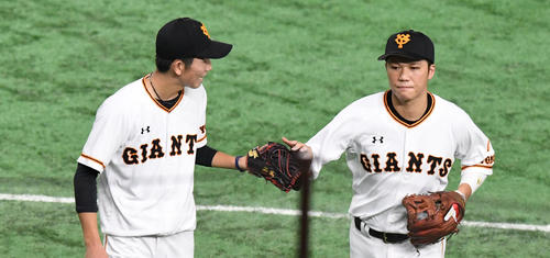 2回無失点に抑えた戸郷（左）は坂本勇人とタッチを交わす（撮影・奥田泰也）