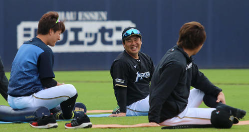 練習前にストレッチをしながらチームメートの渡辺（左）、西川（右）と談笑する日本ハム横尾（撮影・山崎純一）