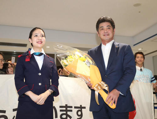 日本シリーズ進出を決め、福岡空港の到着口で花束を贈られる工藤監督（撮影・梅根麻紀）