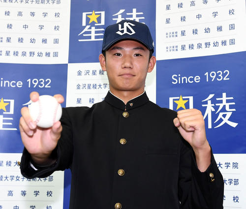 ヤクルトの交渉権獲得が決まった星稜・奥川は、ボールを手に帽子をかぶり写真撮影をする（撮影・奥田泰也）