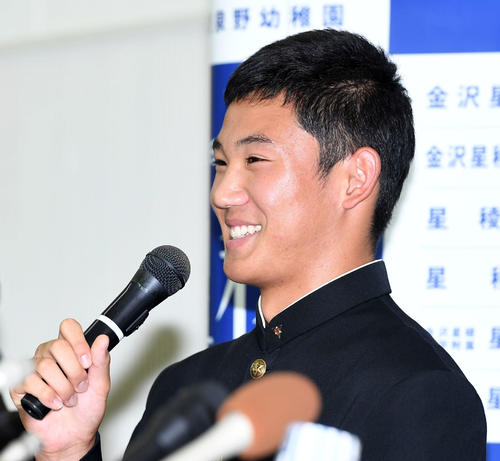 ヤクルトに1位指名を受けた奥川恭伸は笑顔で会見を行う（撮影・奥田泰也）