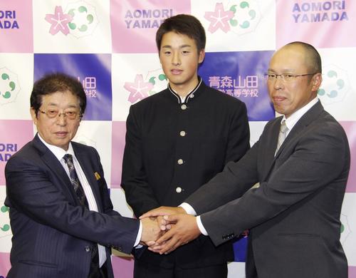 青森山田高の花田惇校長（左）、兜森崇朗監督（右）と握手する巨人から1位指名の堀田賢慎投手（共同）