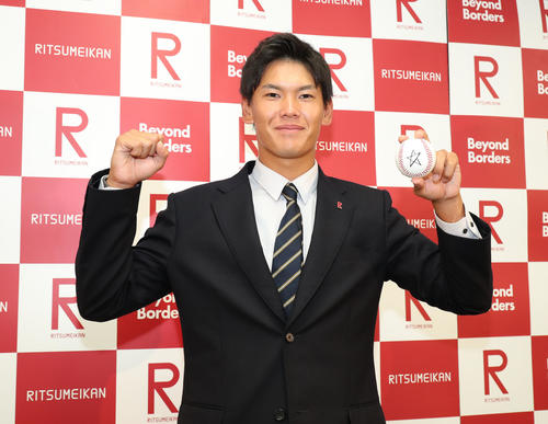 DeNAから2位指名を受けて、白星ボールを持ってガッツポーズする立命大、坂本裕哉（中央）（撮影・白石智彦）