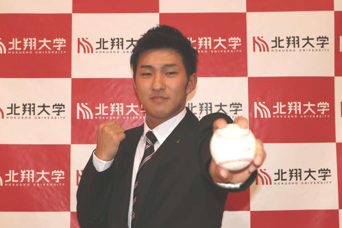 ロッテから育成1位指名を受け、ボールを手にガッツポーズする北翔大・本前（撮影・山崎純一）