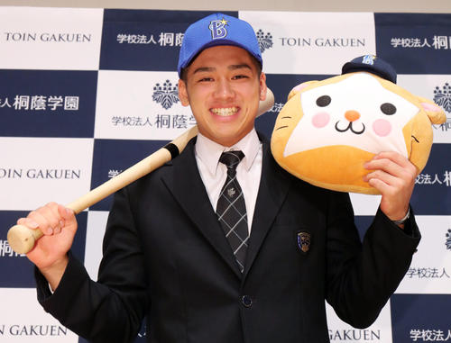 DeNAから単独1位指名を受けた桐蔭学園・森はバットとDB．スターマンのぬいぐるみを手に笑顔で写真に納まる（撮影・垰建太）