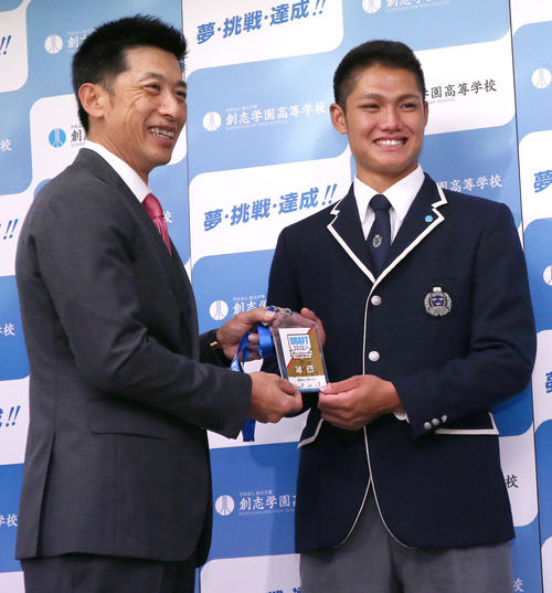 指名あいさつ後、矢野監督（左）自らが書いたサイン入りドラフトIDを受け取り笑顔を見せる創志学園の西（撮影・上山淳一）