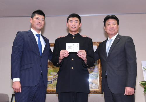 星稜・奥川（中央）はヤクルト高津監督のメッセージの入ったドラフト当たりクジを手に笑顔。左は阿部担当スカウト、右は伊東編成部長（撮影・奥田泰也）