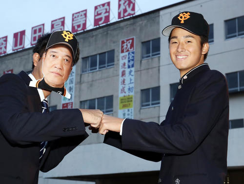 巨人1位指名でスカウトからのあいさつを受けた青森山田・堀田は、原辰徳監督のお面を付けた関係者と笑顔でグータッチ（撮影・浅見桂子）