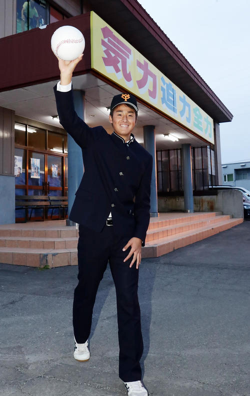 巨人1位指名でスカウトからのあいさつを受けた青森山田・堀田は、学校スローガン「気力・迫力・全力」のボードを背に笑顔でシャドーピッチング（撮影・浅見桂子）